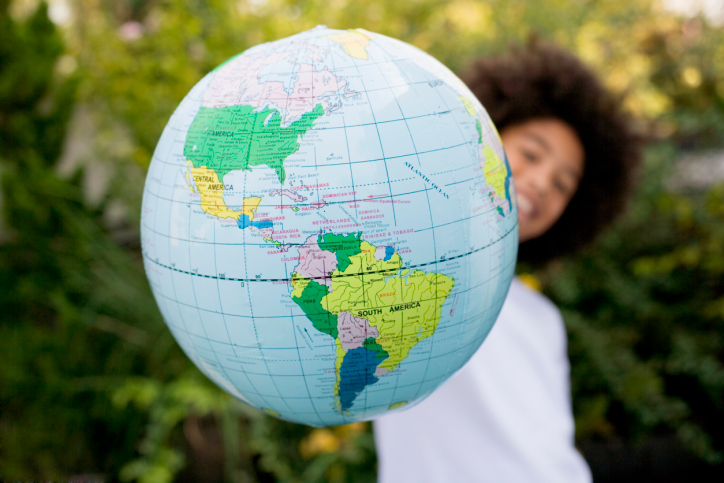 Boy holding globe, representing larger world full of dozens of religions