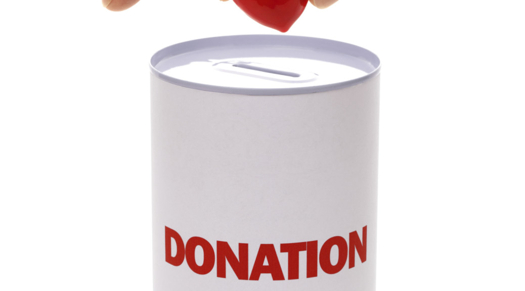 A can labeled donation with a heart being dropped in