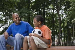 Mentor and boy sitting on picnic table having a conversation.