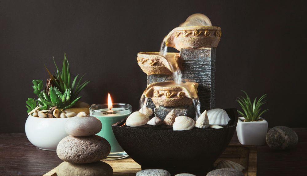 A homemade altar made of a succulent, some stones, and a water fixture.