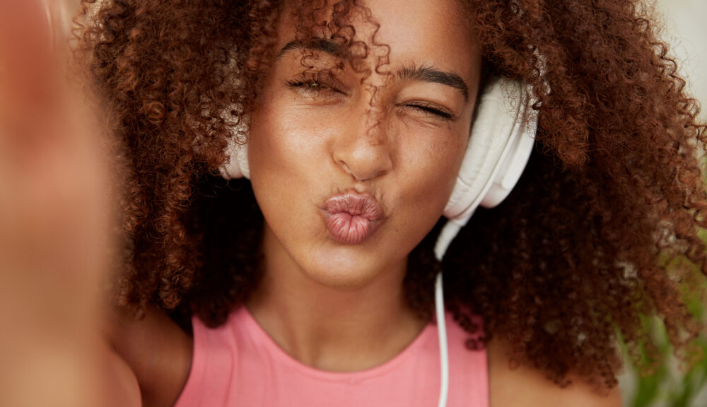 A woman lightens her mood by listening to some upbeat music.