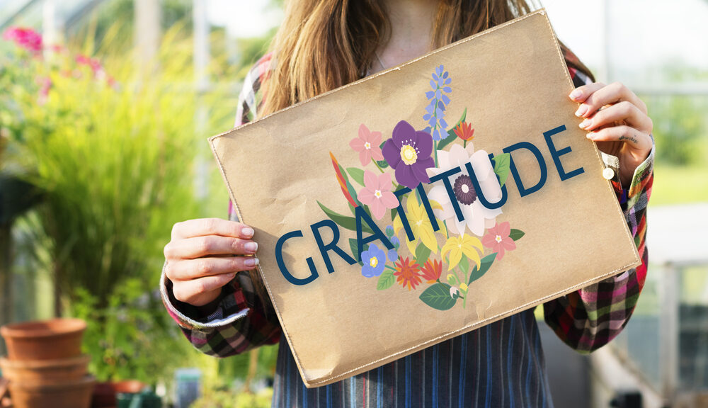 A woman holds up a sign to show gratitude.