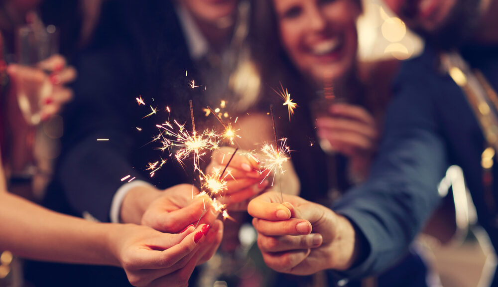 A bunch of people hold sparklers--just one of many superstitions around New Years.