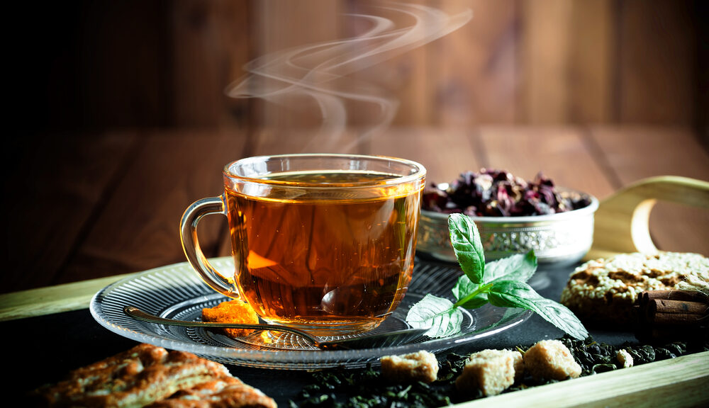 A steaming cup of tea on a plate. Ever though of adding tea to your daily ritual?
