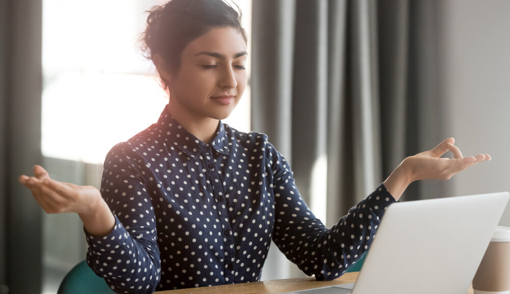 A woman sits in front of her loading computer--exhibiting patience.