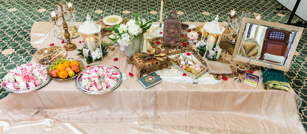 A table replete with many items from popular Persian wedding traditions.