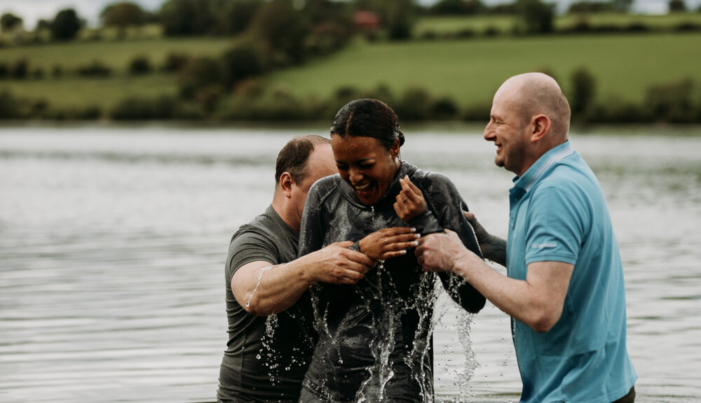 A woman is baptized by two men.