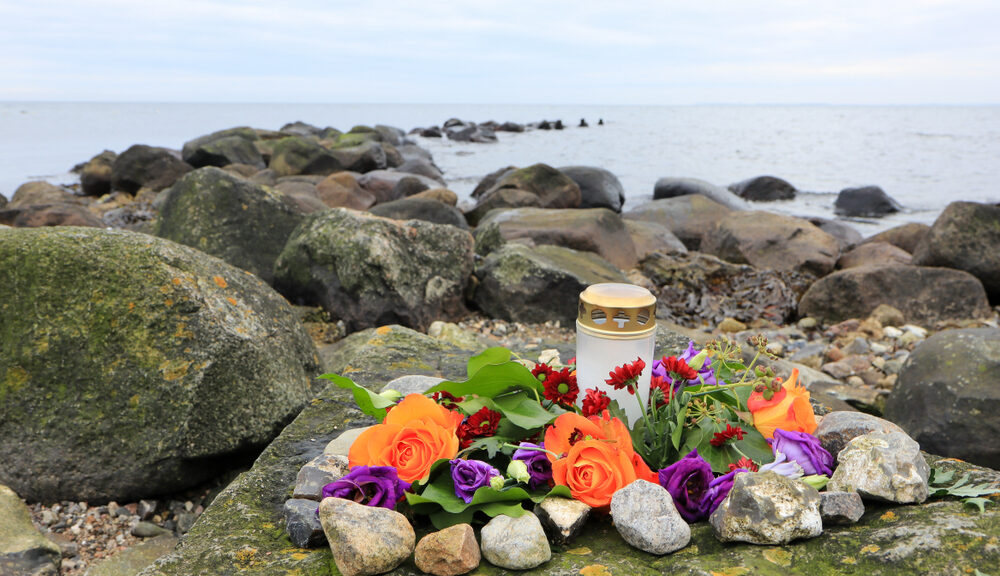 A gravesite commemorating the deceased near the ocean.