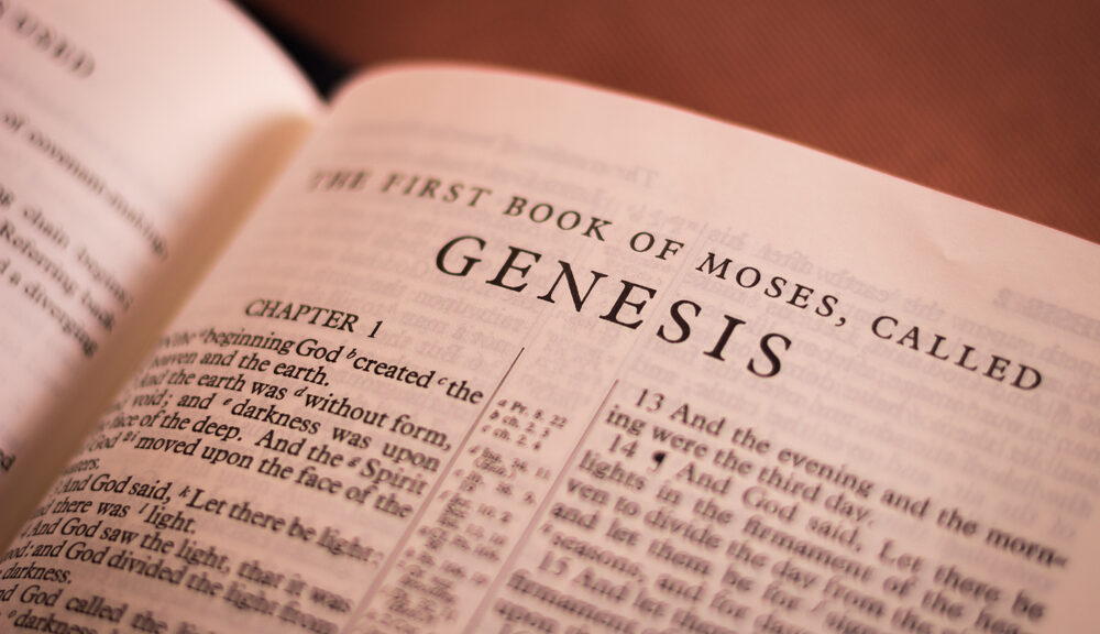 A picture looking down on an open Bible turned to the first page of Genesis.