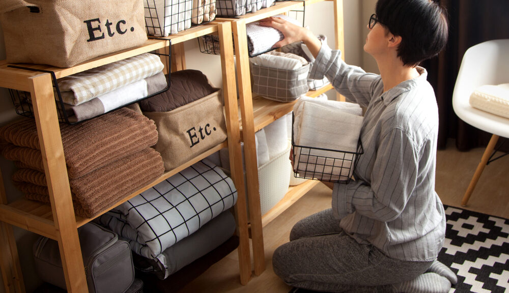 person kneeling organizing shelf for Spring cleaning