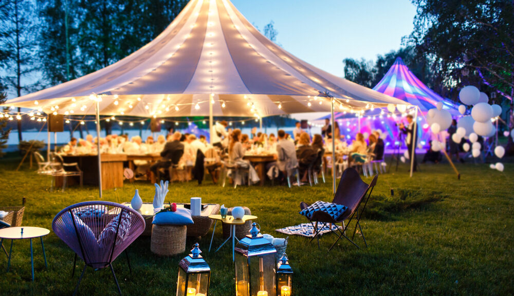 A tent is pitched on a lawn for a garden wedding.