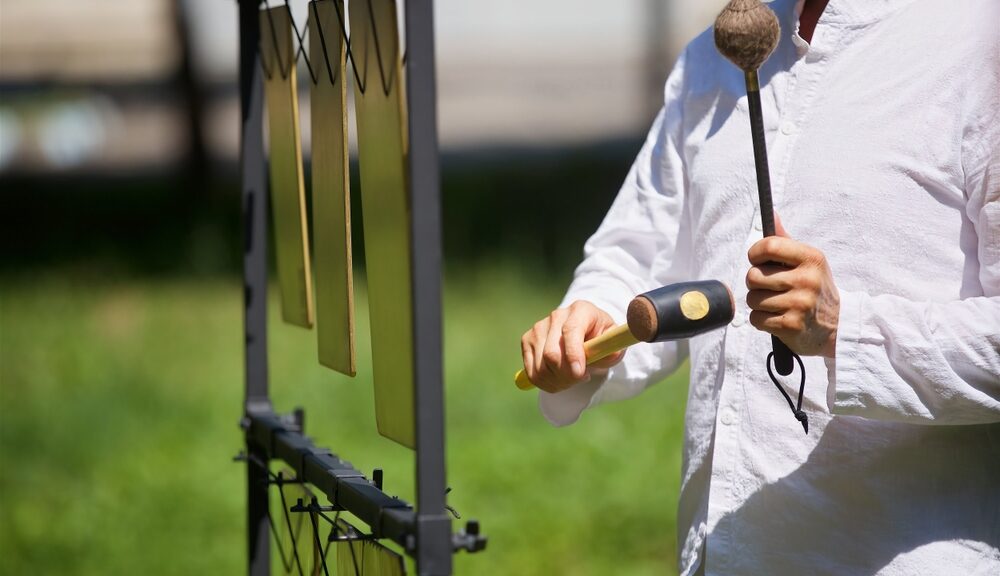 A man plays a set of chimes.