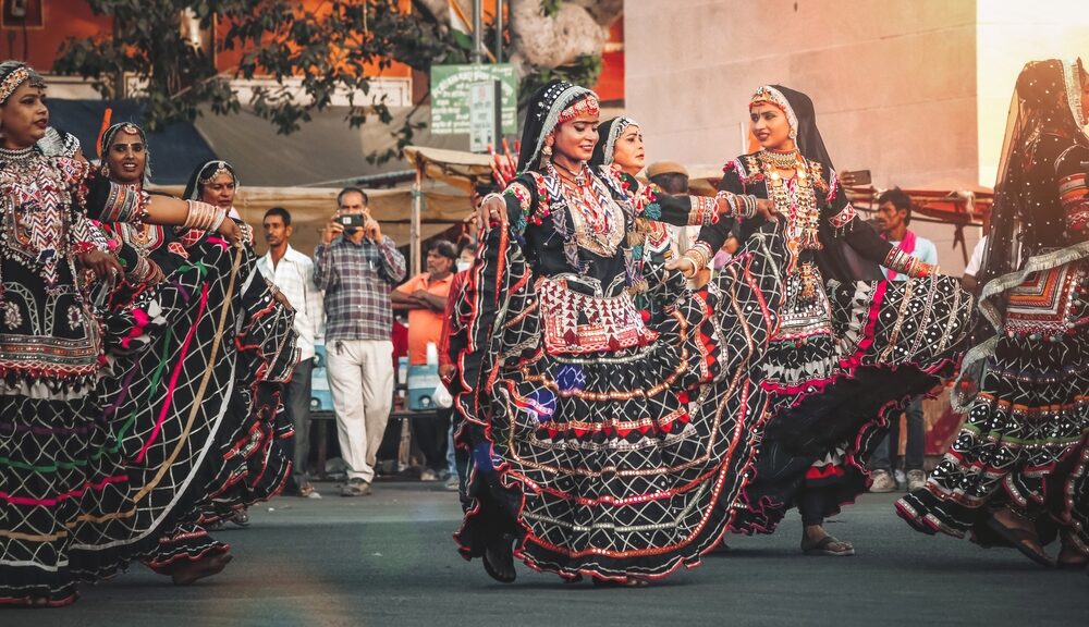A group of women dance in the street.