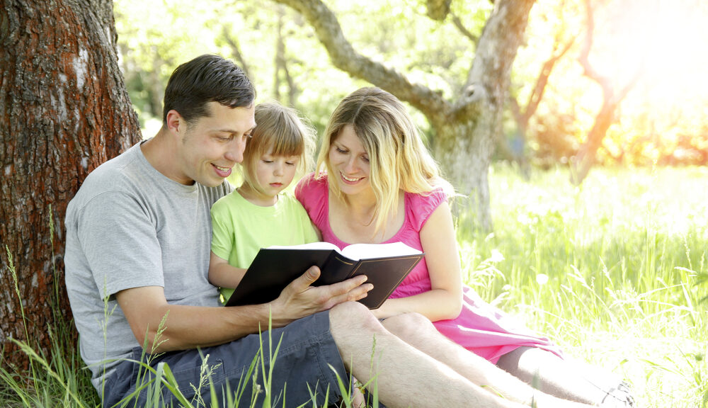 family reading under tree