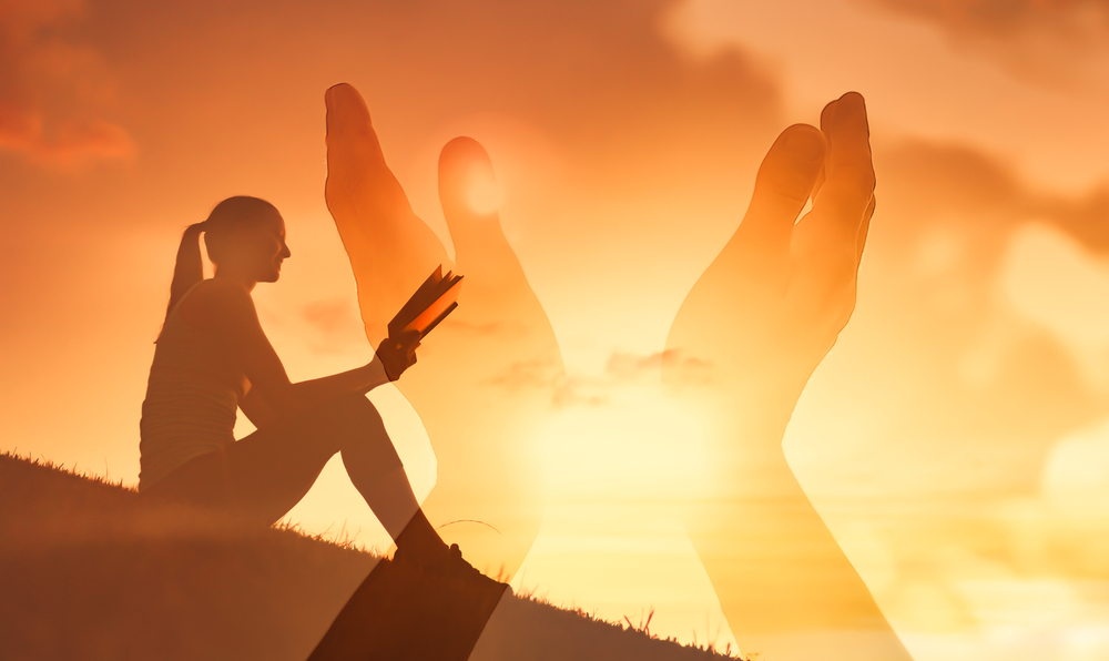 woman reading and praying outside partaking in spiritual practices for the summer